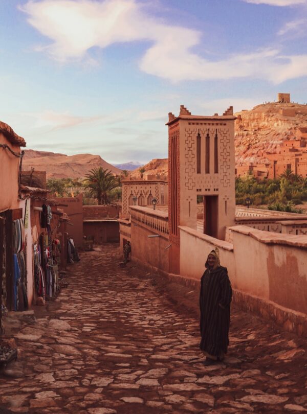 people walking on pathway near brown concrete building during daytime